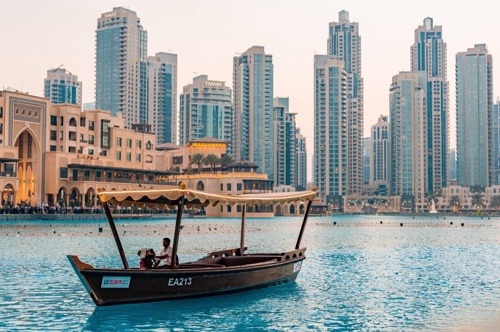 Tradiční dřevěná loď abra na vodě před panoramatem mrakodrapů Downtown Dubai