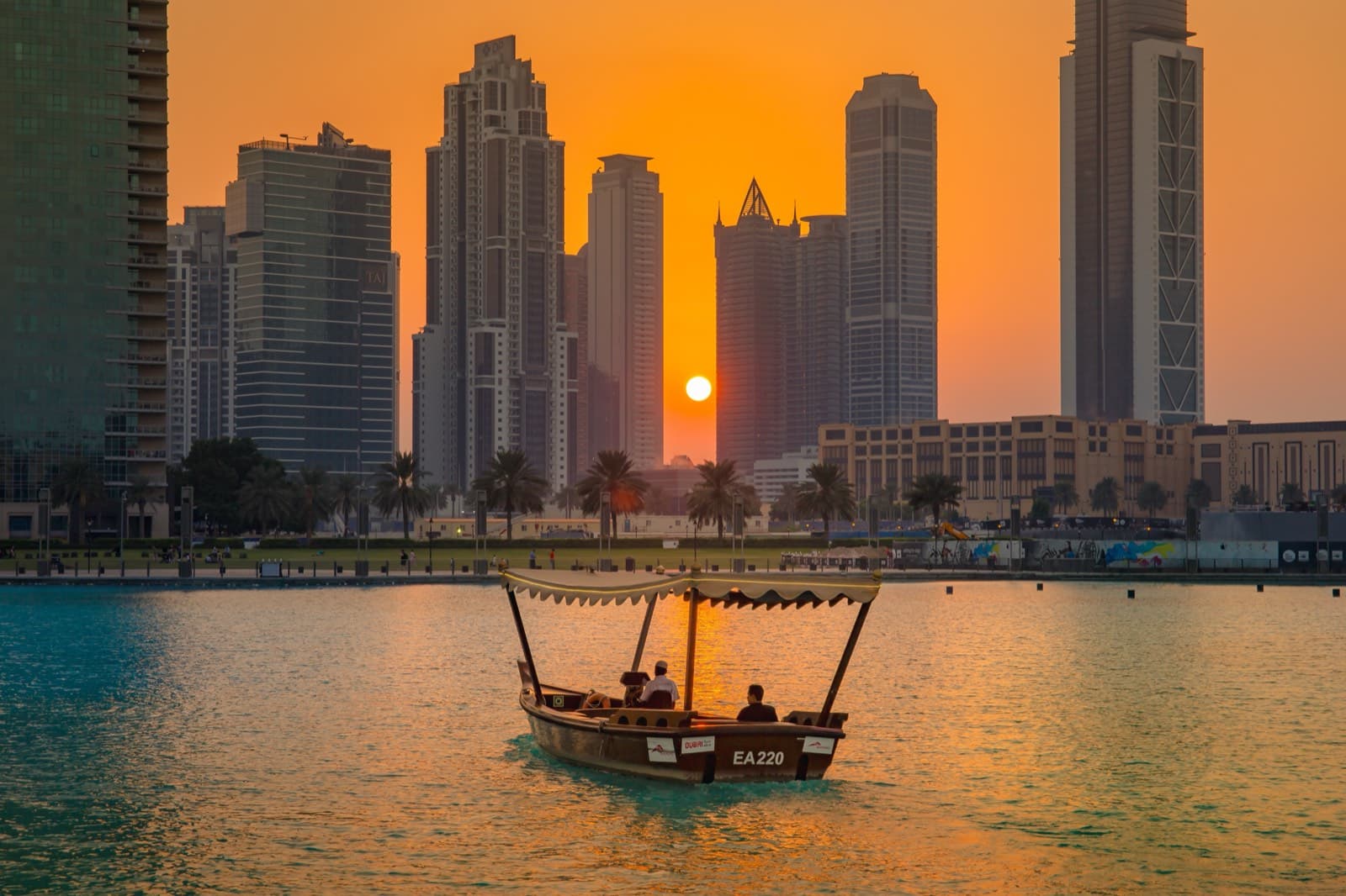 Tradiční loď abra na jezeře u Burj Khalifa při západu slunce
