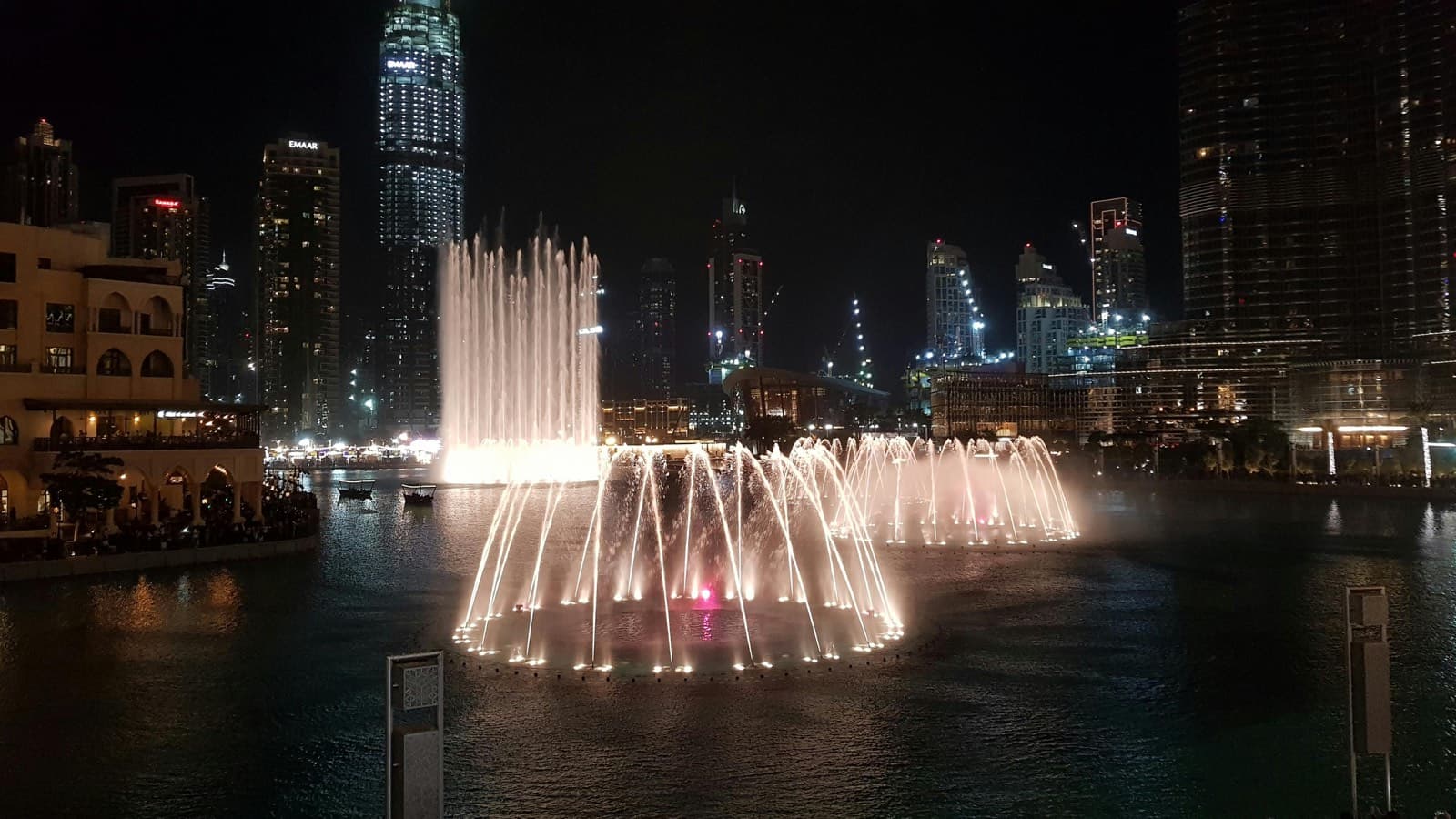 Večerní fontánová show Dubai Fountain s osvětlenými vodotrysky pod Burj Khalifa